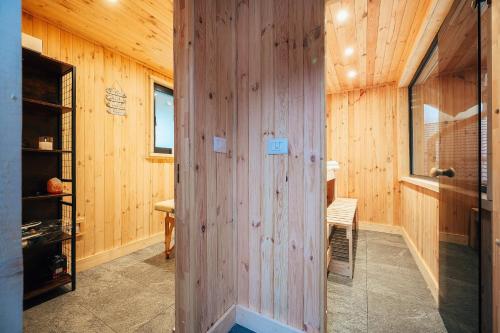a room with a wooden wall with a table and a chair at Fox Chalet in Molidu