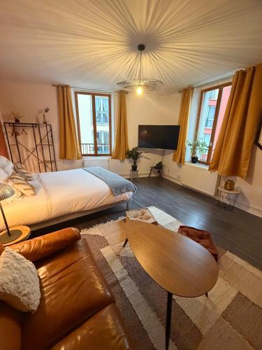 a living room with a bed and a couch at L'instant Nevers in Charleville-Mézières