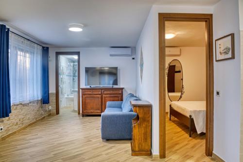 a bedroom with a bed and a blue chair in a room at Villa Maria Gaeta in Gaeta
