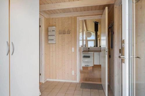 a kitchen with wooden walls and a door to a hallway at JB406-Fjerritslev-Aspevej-68 in Fjerritslev