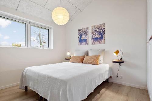 a white bedroom with a white bed and a window at 20514-Samso-Plantagevej-17 in Sælvig