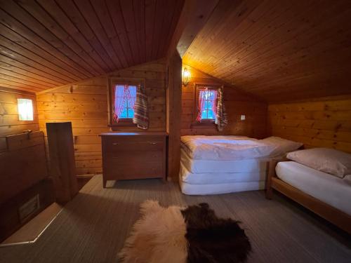 a bedroom with two beds in a wooden cabin at Chalet in Niederwald in Niederwald