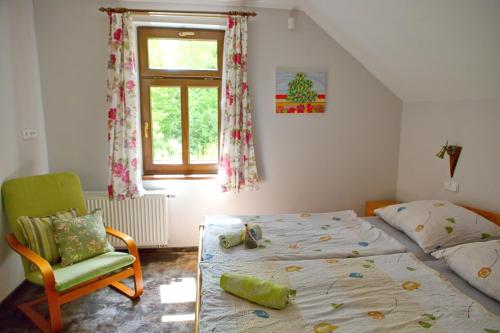 a bedroom with a bed and a chair and a window at Penzion Arosa in Růžová