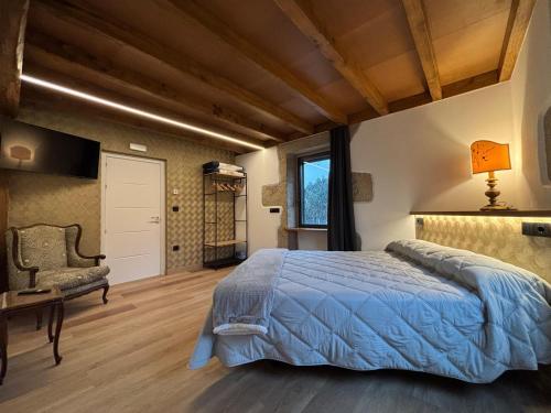a bedroom with a bed and a chair and a window at Casa do Cabo in Morás