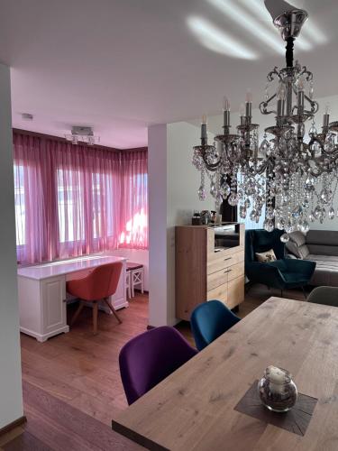 a living room with a table and purple chairs at Bright & Cozy Apartment in Villach