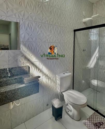 a bathroom with a toilet and a sink and a mirror at Virgulino Residence in Piranhas