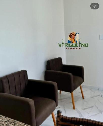 two chairs and a couch in a room at Virgulino Residence in Piranhas