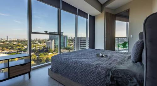 a bedroom with a large bed with a large window at Parklife Pabellón in Guadalajara