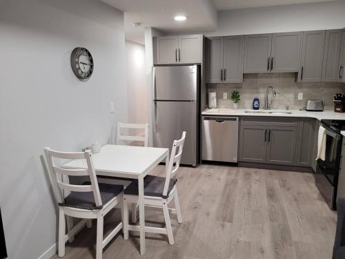 a kitchen with a table and chairs and a refrigerator at Modern 2BR Suite with Private Yard in Calgary