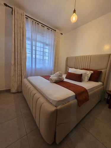 a large bed in a bedroom with a window at Rio Cabins in Nyeri