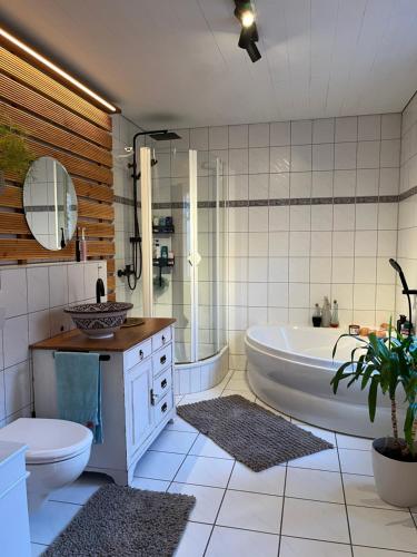 a bathroom with a tub and a toilet and a sink at Olive Garden in Groß-Bieberau