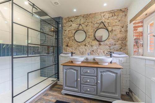 a bathroom with two sinks and two mirrors at Bon Chez Nous in Saint-Amand-Jartoudeix