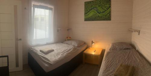 a bedroom with two beds and a lamp and a window at Domček in Budimír