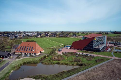 an aerial view of a building next to a river at Farm house Van der Valk Hotel Leeuwarden in Leeuwarden