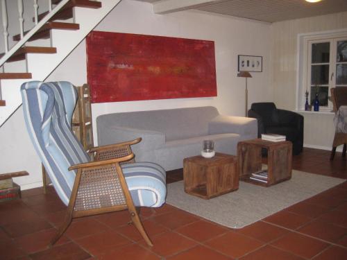 a living room with a couch and a chair at Ferienhaus von der Ahe in Mohrkirch