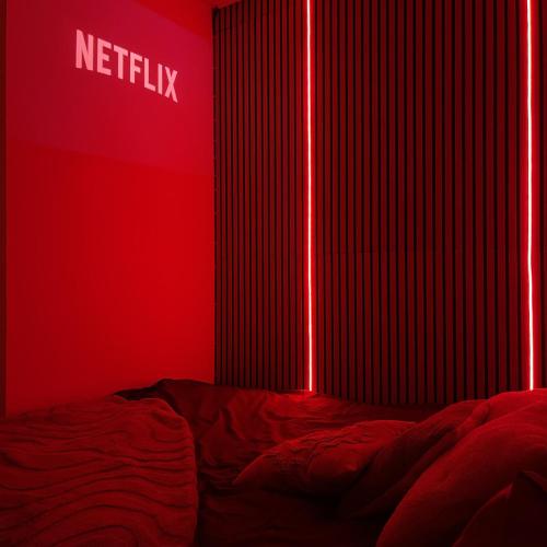 a red bedroom with a bed with a netflix sign at Love room - Montélimar in Montélimar