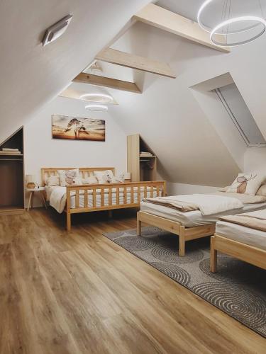 a attic bedroom with two beds and a rug at Ubytování Ve dvorku in Uherčice