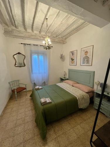 a bedroom with a green bed and a window at La Casetta di Nonno Mario in Chiusdino