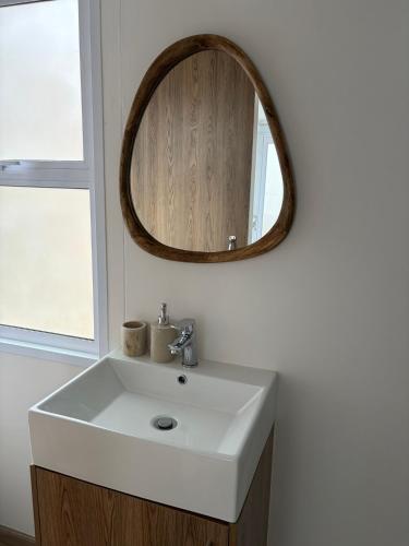 a bathroom with a white sink and a mirror at Khayalena Beach House - Tides Reach in Umdloti