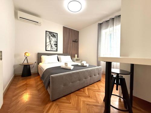a bedroom with a bed and a table and a window at Apartments Nona in Pula