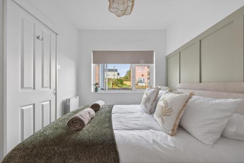 a white bedroom with a bed with white pillows at Ty Sage in Pembrokeshire
