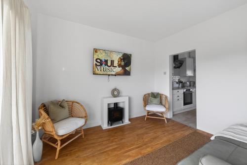 a living room with two chairs and a fireplace at Ty Sage in Pembrokeshire