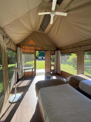 a bedroom with two beds and a ceiling fan at Mongwe Safari Camp in Nyakarura