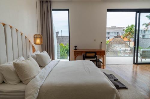 a bedroom with a large white bed and a desk at Unity Villa 1 Canggu in Canggu