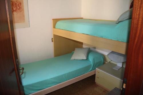 カスティリオーネ・デッラ・ペスカーイアにあるCastiglione Della Pescaiaの小さな部屋の二段ベッド2台(椅子付)