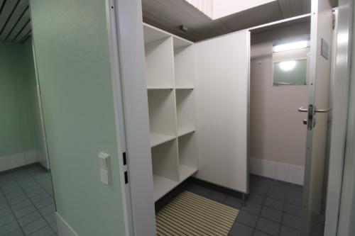 a walk in closet with white shelves and a door at Haus Norderhoog Wohnung 39 in Westerland