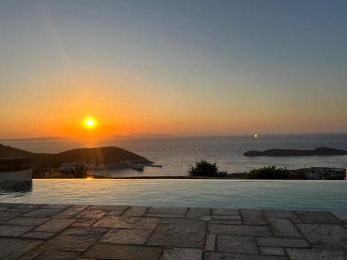 a sunset over the ocean with a swimming pool at Sunset Heaven Villa on Kea in Korissia