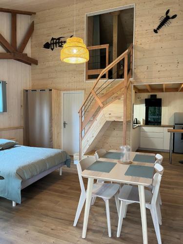 a bedroom with a bed and a table and a staircase at ty loft keremma in Tréflez