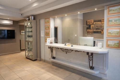 a bathroom with a counter with a large mirror at Hotel Prins Boudewijn in Knokke-Heist