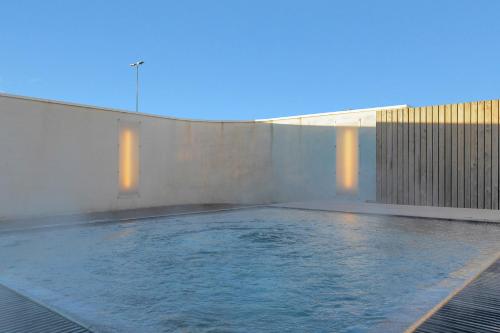 ein Schwimmbecken, aus dem Wasser herauskommt in der Unterkunft Hotel Vellir in Hafnarfjördur