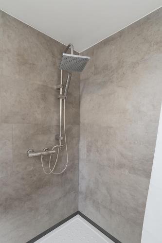 a shower with a shower head on a wall at My Loft in Hagen