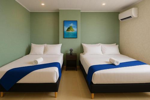 two beds in a small room with at HOTEL COSTA AZUL SAI in San Andrés