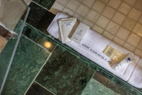 a bathroom counter with towels and soap on avisor at Mount Elgon Hotel & Spa in Mbale