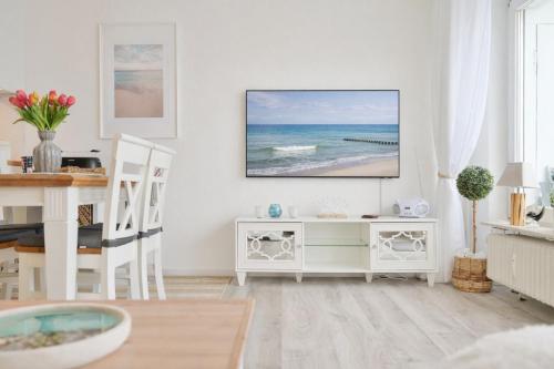 a living room with a tv on a white wall at Küstenkinder Whg 17 in Kellenhusen