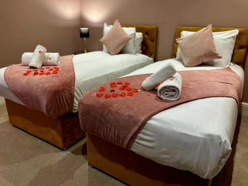 two beds in a hotel room with towels on them at Hamilton Luxury - The James Suite in Scorton
