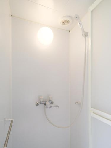 a shower with a shower head in a bathroom at Akabane Dormitory-Men Only in Tokyo