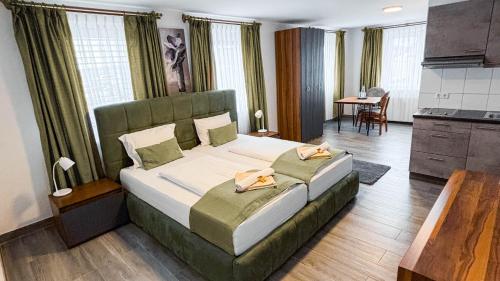 ein Schlafzimmer mit einem großen Bett und eine Küche in der Unterkunft E&B Hotel Korb bei Waiblingen & Stuttgart in Korb