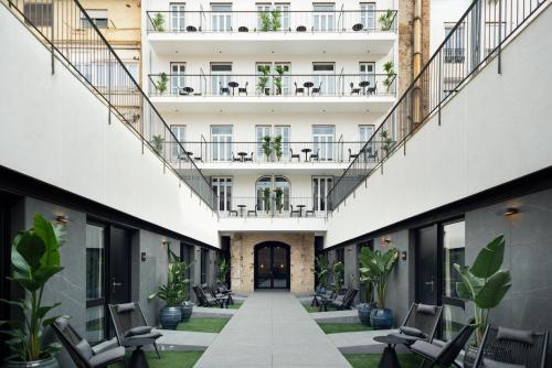 an internal courtyard of a building with chairs and plants at Blanq Gran vía in Valencia