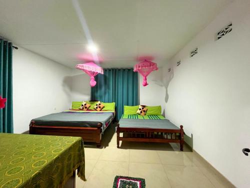 two beds in a room with green curtains at PINI ROO Villa in Badulla