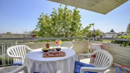 a table and chairs on a balcony with a table and drinks at A casa di Attila DesenzanoLoft Official Partner Homes & Villas by Marriott Bonvoy in Desenzano del Garda