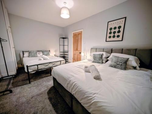 a bedroom with a large white bed with pillows at 4, The Croft, Bellingham in Bellingham
