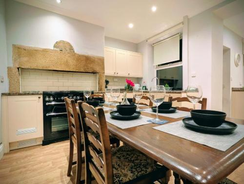 a kitchen with a wooden table with wine glasses at 4, The Croft, Bellingham in Bellingham