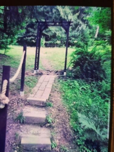 a stone path leading to an arch in a field at Abenteuerurlaub im Tannenwald in Ilmenau