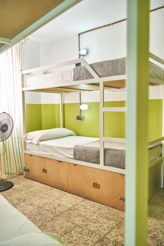 a room with two bunk beds and a fan at LOFT HOSTAL Group in Lloret de Mar
