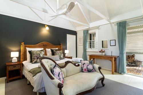 a bedroom with a bed and a chair and a ceiling at Five Mountains Guest Farm & Spa in Wellington