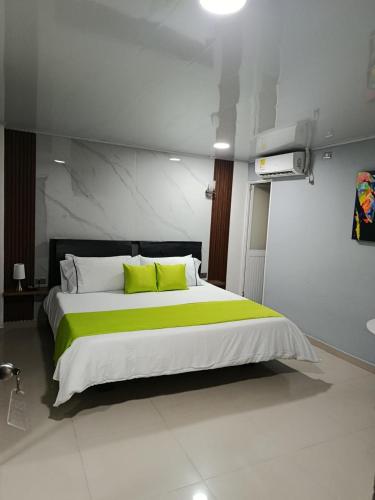 a bedroom with a large bed with yellow pillows at HOTEL LIGHT PLAZA in Aguachica